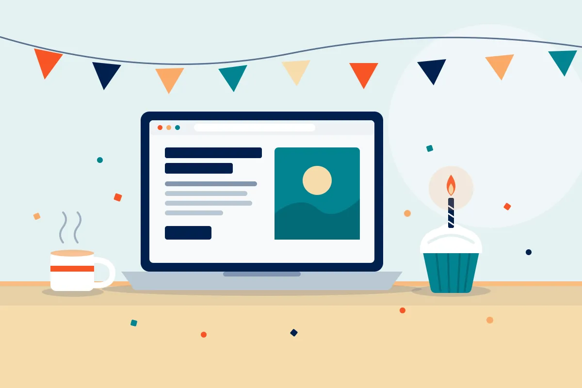 A laptop showing a blog page on a desk, with a coffee mug, a cupcake with a single lit candle, and a string of bunting behind it.